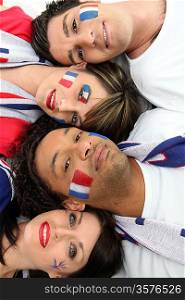 Four French football supporter laying together
