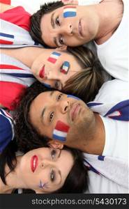 Four French sports fans laying together