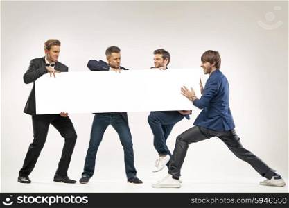 Four friends pushing the billboard
