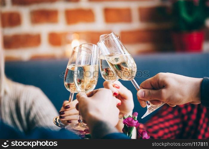 Four glasses of champagne joined in a toast. Party time and celebration. Close-up shot.. Four glasses of champagne in a toast
