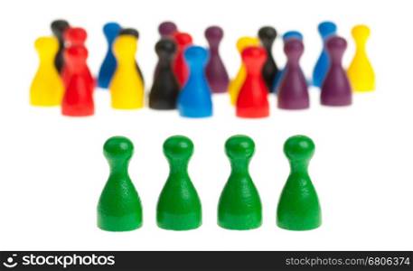 Four green pawns in front of a large group of different colored pawns