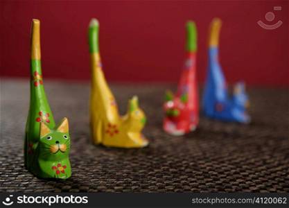 four handcraft cats in colors still over tablecloth