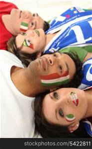 Four Italian soccer fans laying on the floor