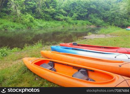 four kayaks on the Bank of the river, sports kayaks on the shore of the pond. sports kayaks on the shore of the pond, four kayaks on the Bank of the river