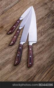 four kitchen knifes on wooden board