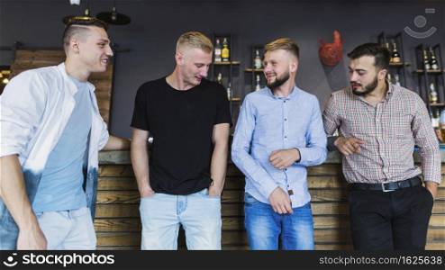 four male friends casual wear standing bar counter