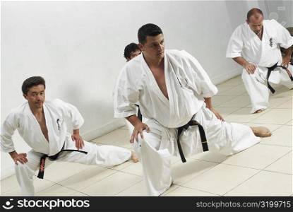 Four mid adult men practicing karate