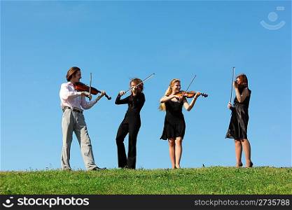 four musicians play violins against sky, focus on left man