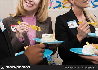 Four office workers eating cake