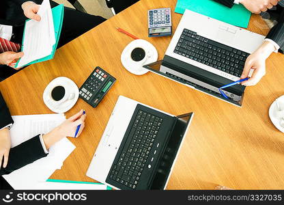 Four people discussing or negotiating a contract ? and having a coffee while doing so