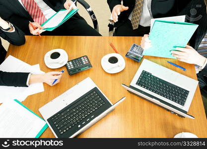 Four people discussing or negotiating a contract ? and having a coffee while doing so