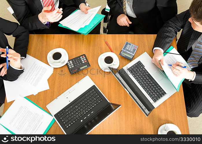 Four people discussing or negotiating a contract ? and having a coffee while doing so