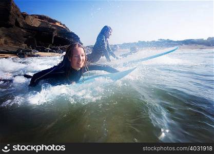 Four people in the water with surfboards