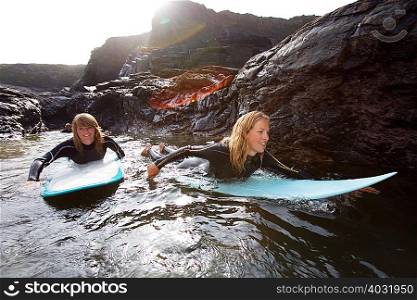 Four people lying on surfboards