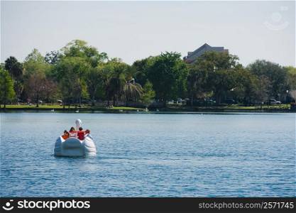 Four people on a pedal boat, Lake Eola Park, Orlando, Florida, USA
