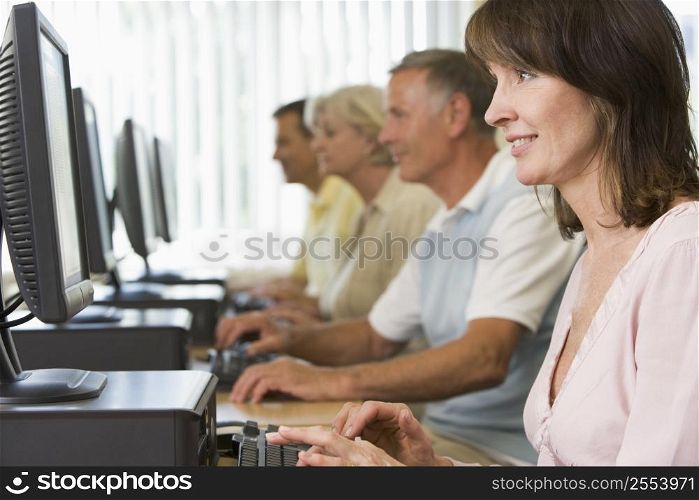 Four people sitting at computer terminals (depth of field/high key)