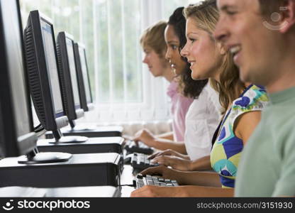 Four people sitting at computer terminals (selective focus)