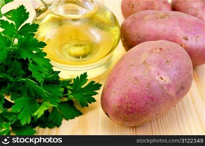 Four red potatoes, a bunch of parsley, vegetable oil in a bottle on the background of wooden boards