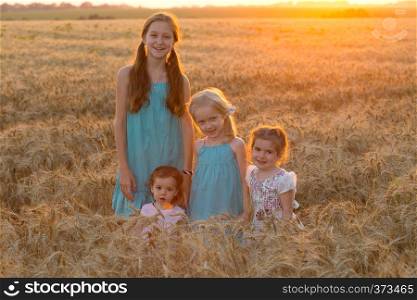 four smiling little girls in a wheat field