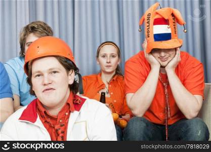 Four soccer fans, watching a game at home, in disbelief about the outcome of the game