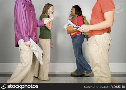 Four students walking along a corridor