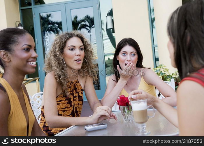 Four teenage girls sitting together and gossiping