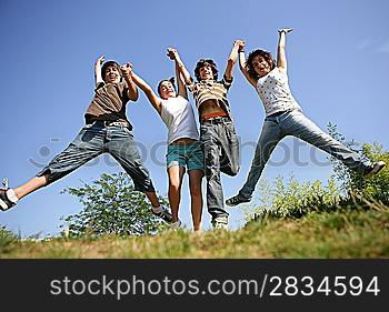 four teenagers jumping