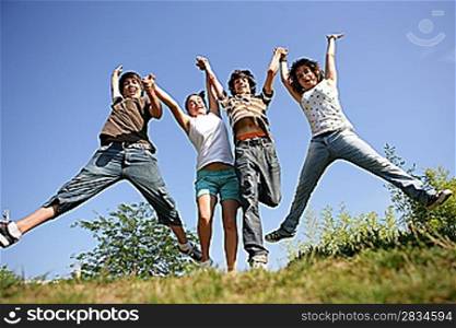 four teenagers jumping