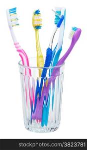 four toothbrushes and interdental brush in glass - family set of toothbrushes isolated on white background