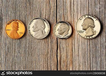 Four US cent coins over wooden background