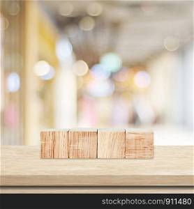 Four wooden cubes on table over blur abtract bokeh light background