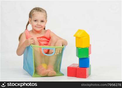 Four-year girl playing in a European-style cubes, isolated on a light background