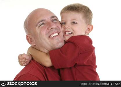 Four year old boy hugging his dad around the neck.