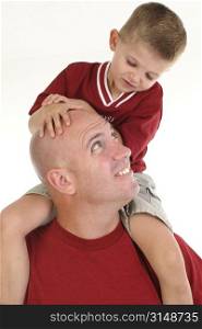 Four year old boy sitting on his father&acute;s shoulders.