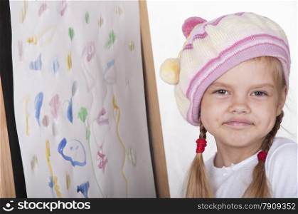 Four-year-old girl playing in artist. girl drew a picture and happily looking at picture.