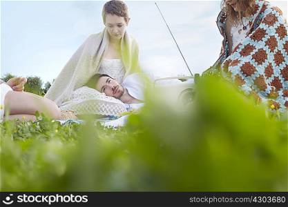 Four young adult friends resting in field