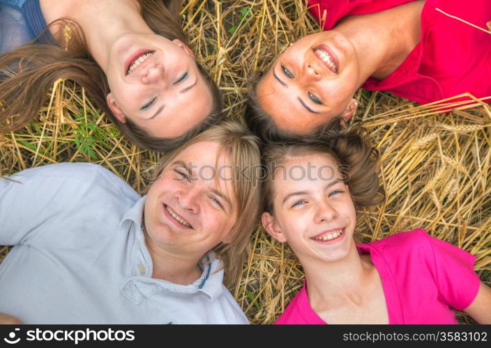 Four young happy people lying on the ground