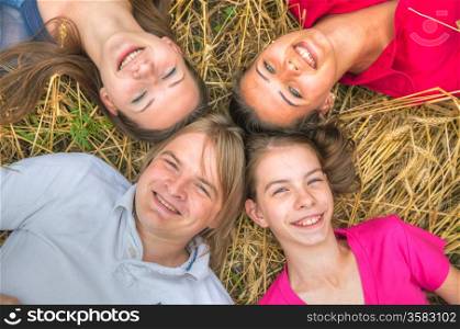 Four young happy people lying on the ground