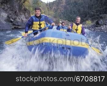 Four young people paddling an inflatable raft