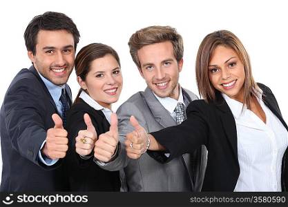 Four young professionals giving the thumbs up
