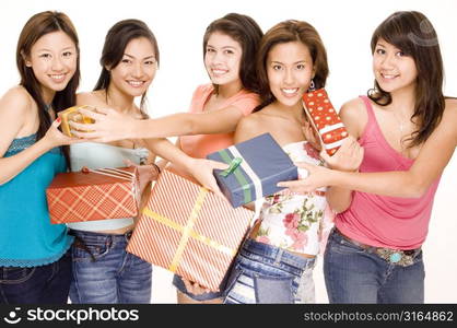 Four young women and a teenage girl exchanging their Christmas gifts