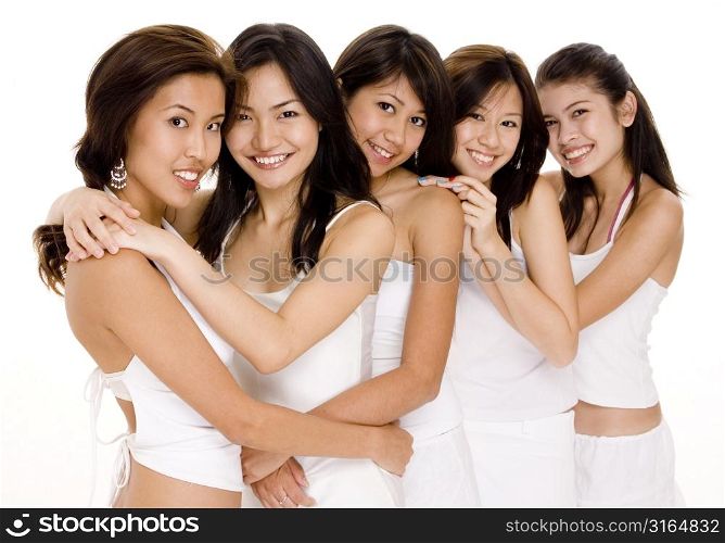 Four young women and a teenage girl standing together and smiling