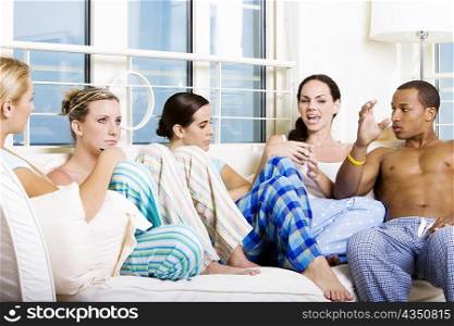Four young women and a young man sitting on a couch