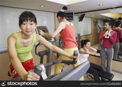 Four young women exercising in a gym