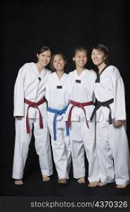 Four young women smiling and standing in gi