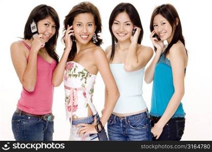 Four young women talking on mobile phones