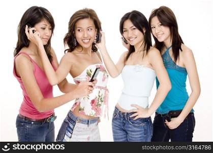 Four young women using each others mobile phones