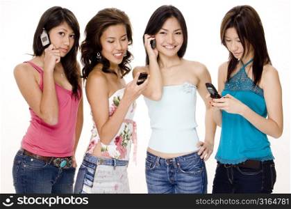 Four young women using mobile phones