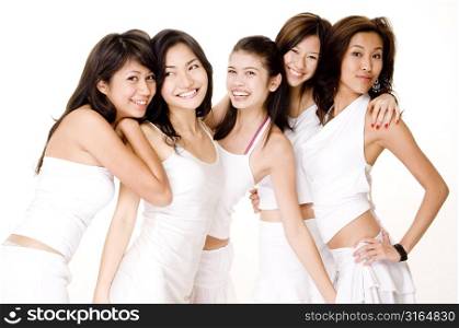 Four young women with a teenage girl standing together and smiling