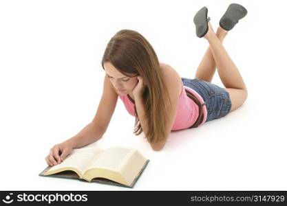 Fourteen year old teen girl laying on floor reading book.